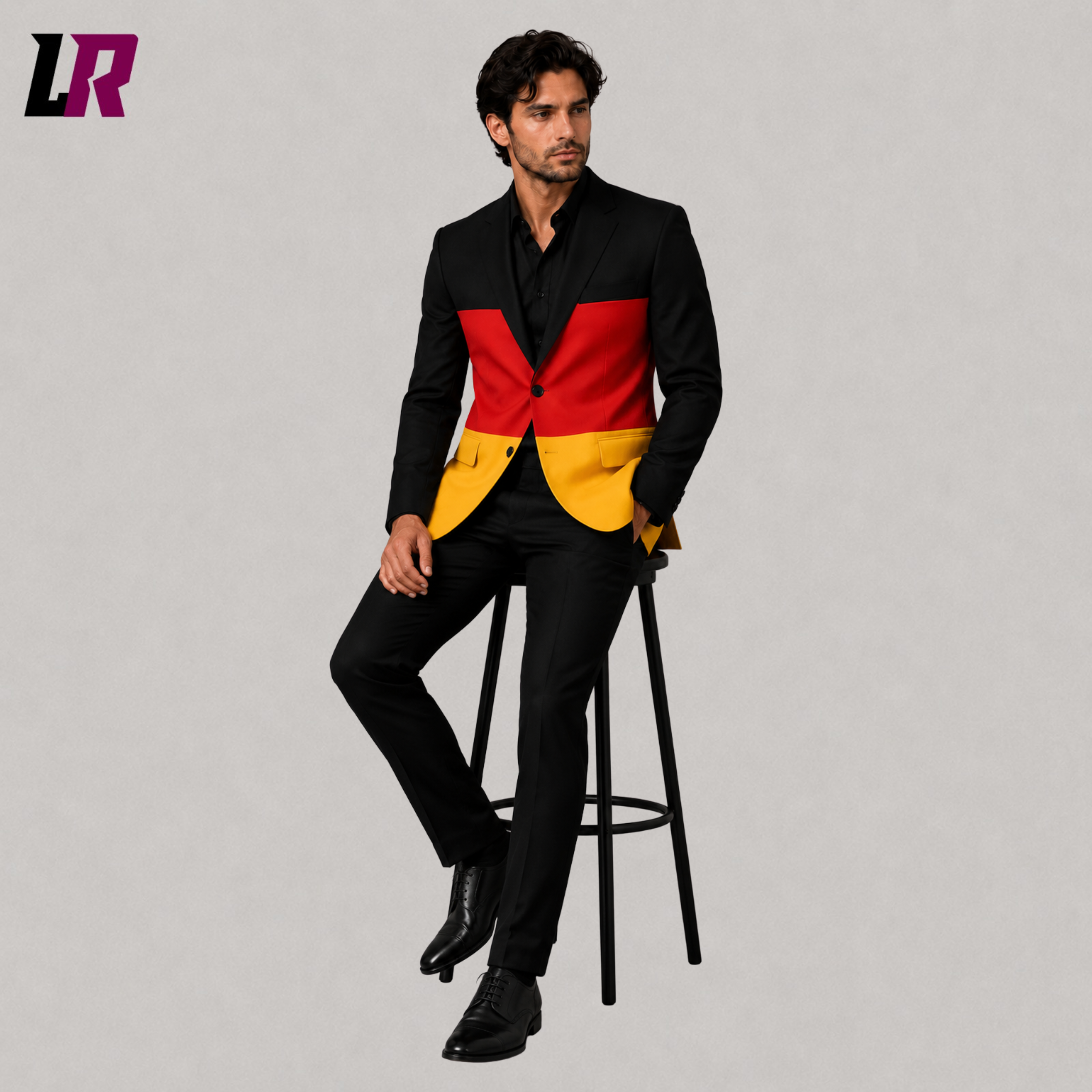 Man wearing a custom tailored German Flag Suit while sitting on a stool in a modern studio portrait