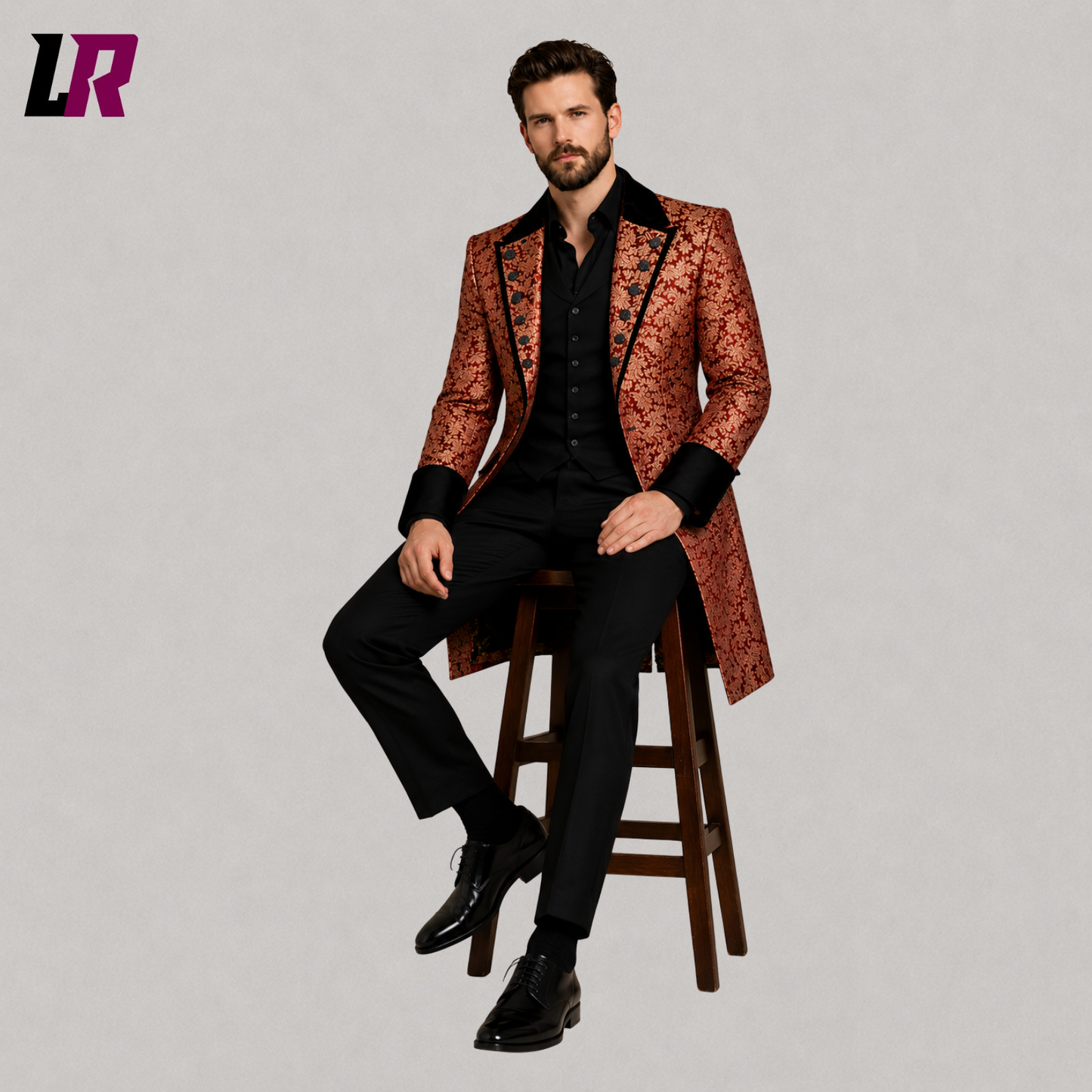 Men's red gold Victorian Gothic long coat with model seated on a stool in a luxury formal fashion pose