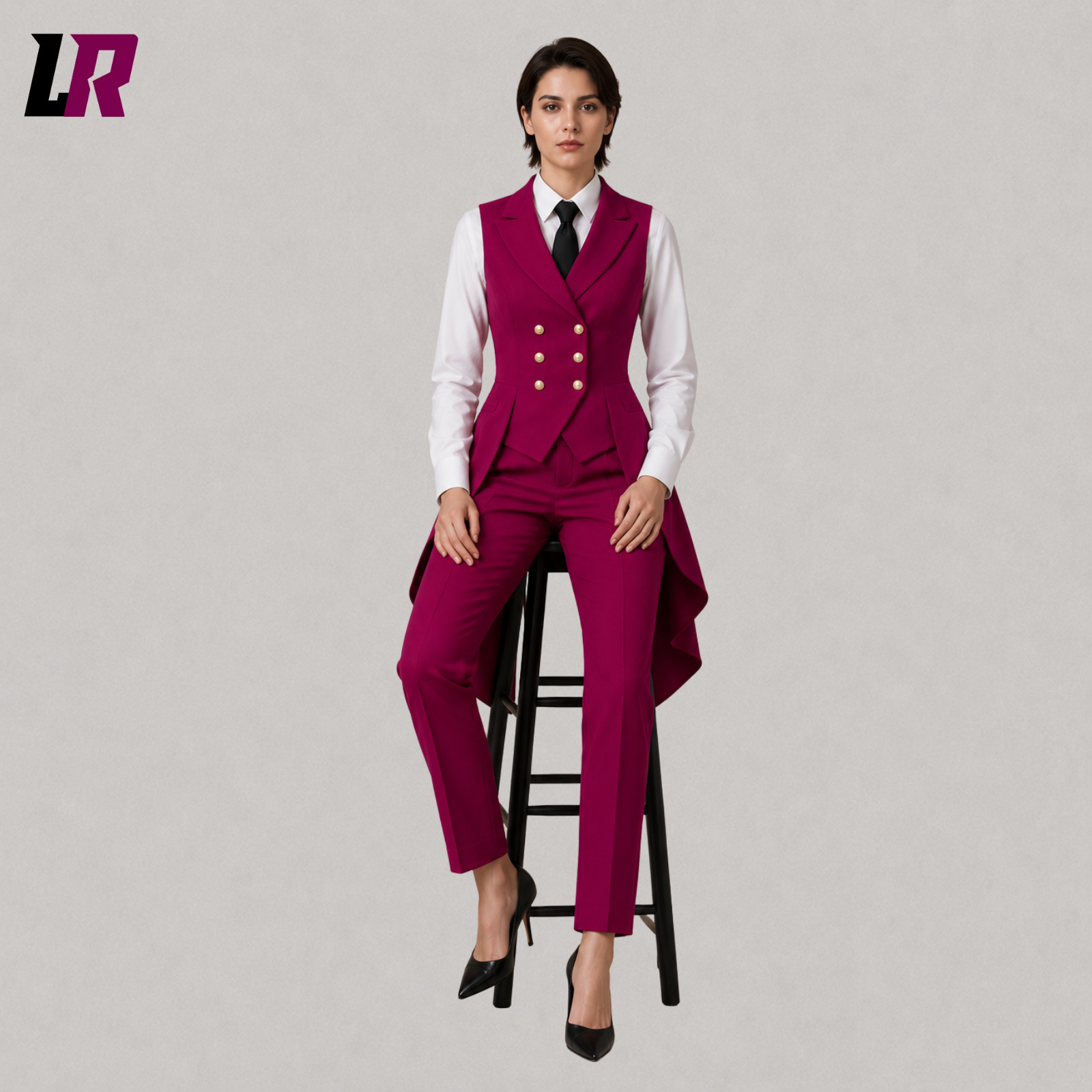Women's luxury fuchsia Victorian tailcoat suit with model seated on a stool in a sophisticated designer fashion pose