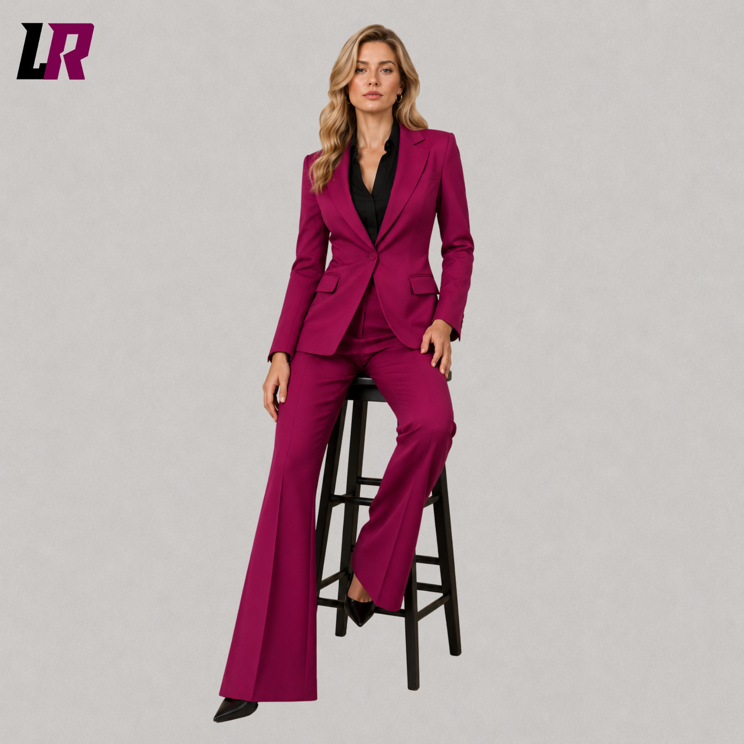 Women's magenta blazer and flare pants suit with model seated on a stool in a luxury formal fashion pose