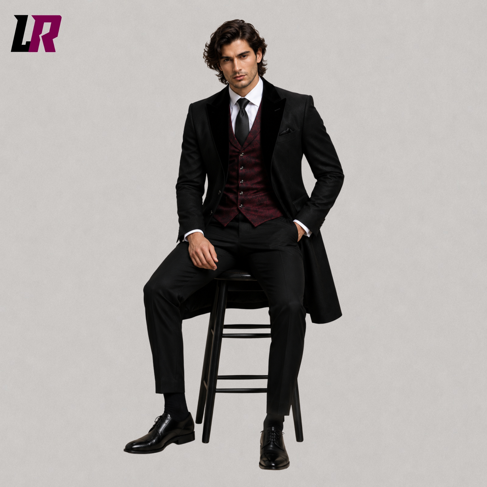 Man sitting on a stool wearing a black Gothic tailcoat suit with burgundy vest
