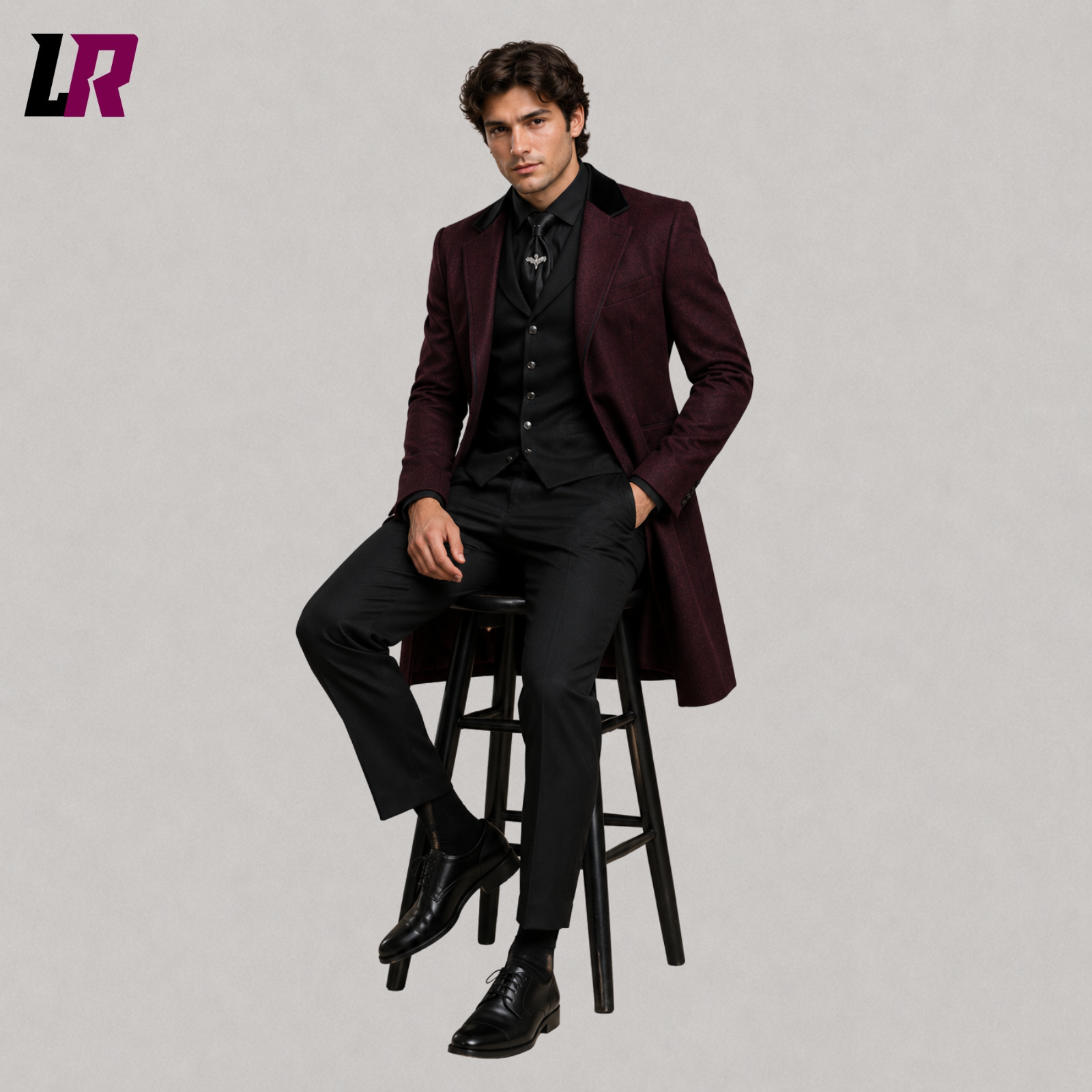 Man sitting on a stool wearing a burgundy Gothic brocade blazer with Victorian formal styling
