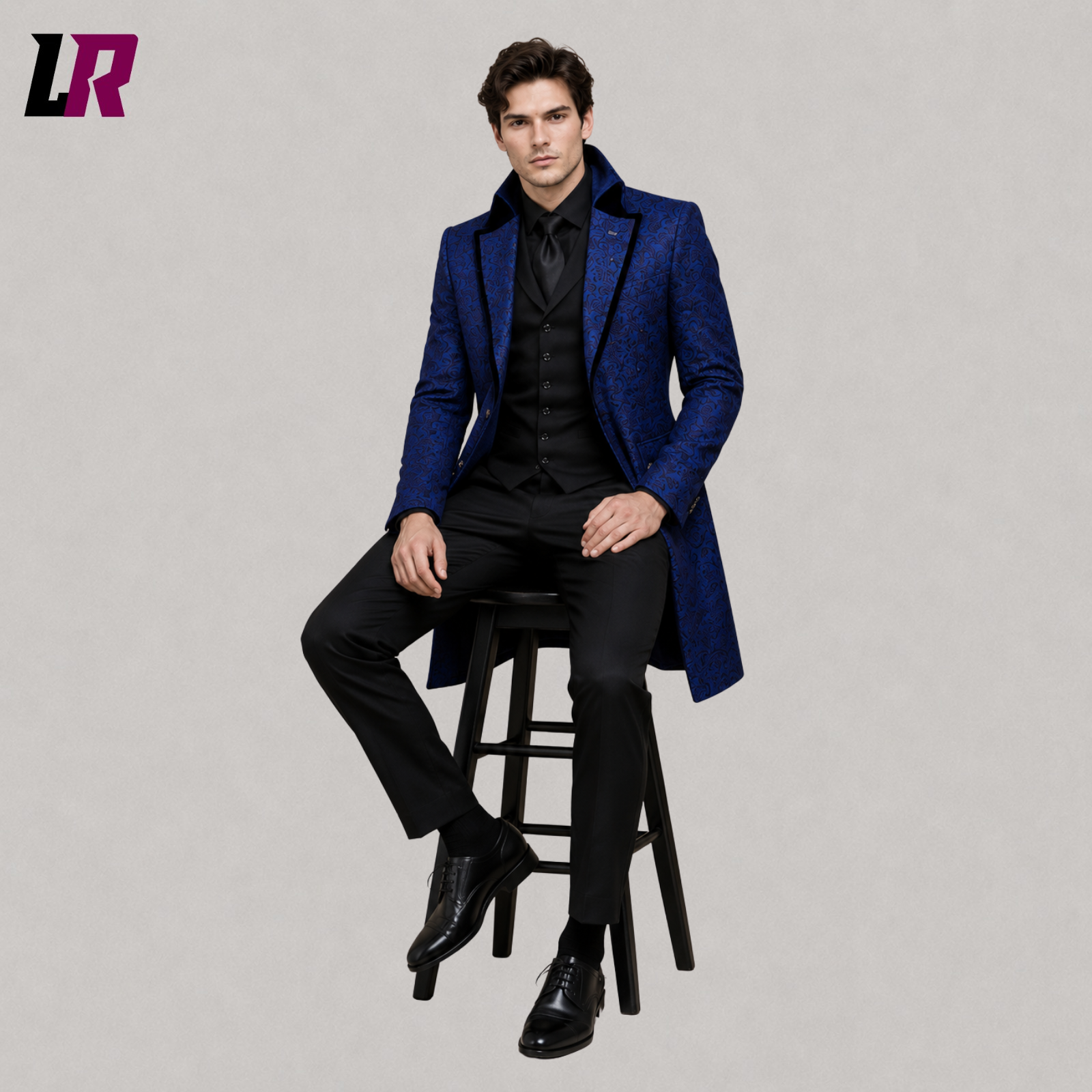 Man sitting on a stool wearing a royal blue Victorian tailcoat for weddings and formal events