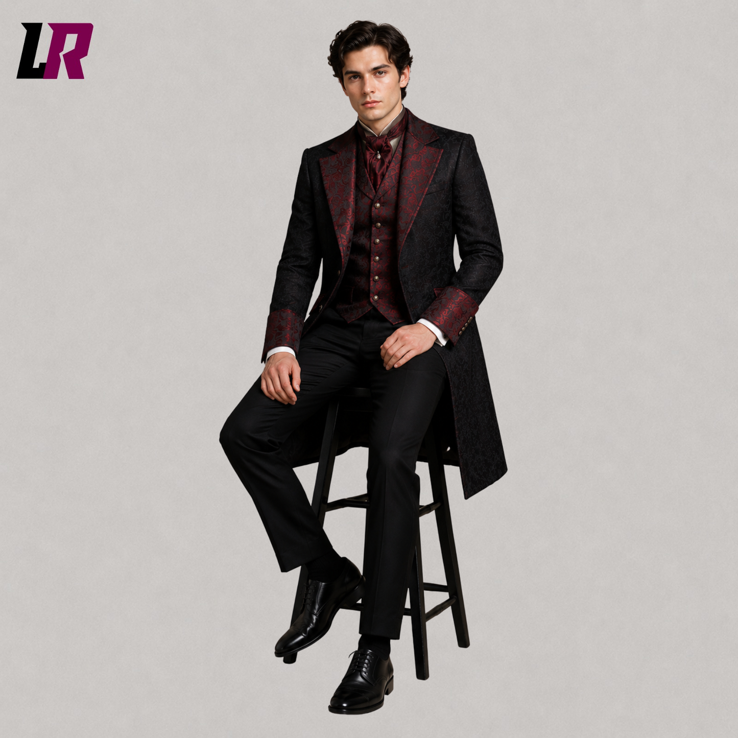Man sitting on a stool wearing a black and red Victorian Gothic tailcoat for weddings and formal occasions