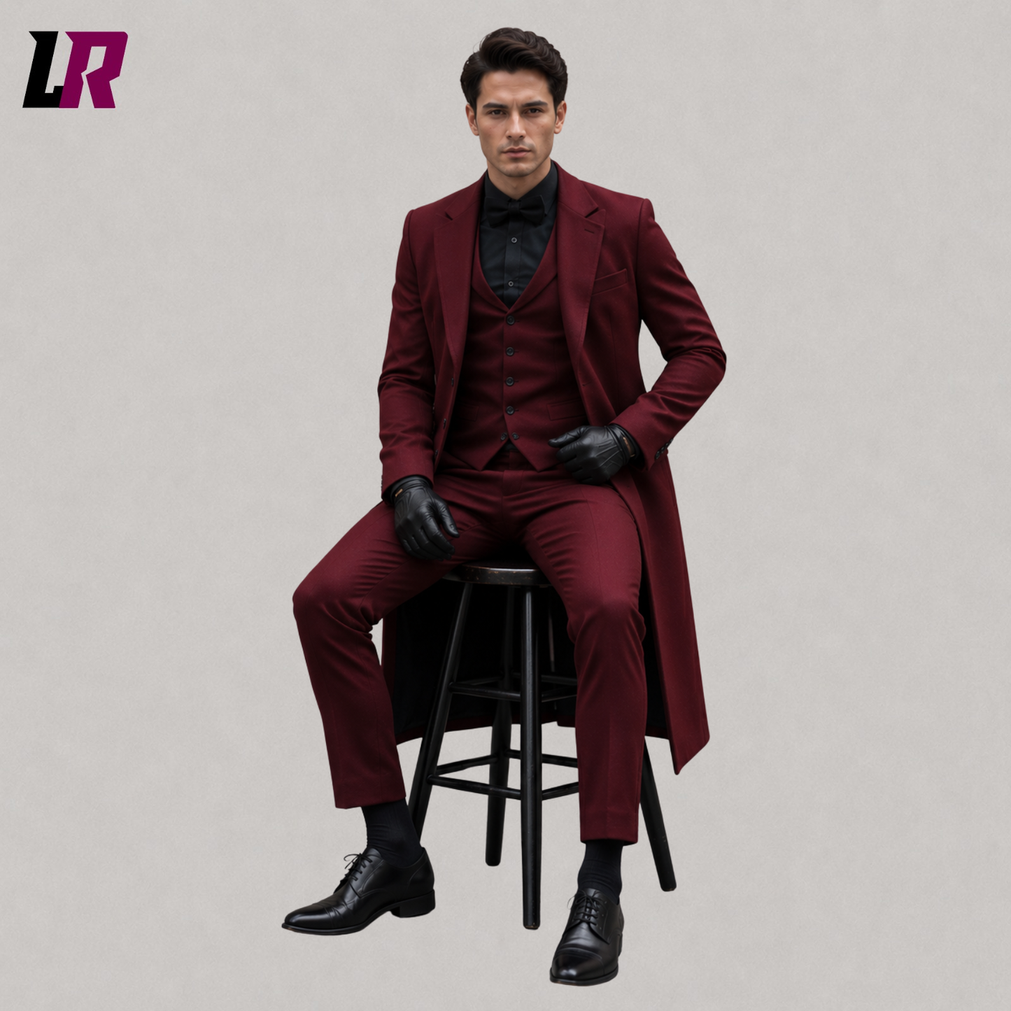 Man sitting on a stool wearing a burgundy Gothic Victorian tailcoat for weddings and formal occasions