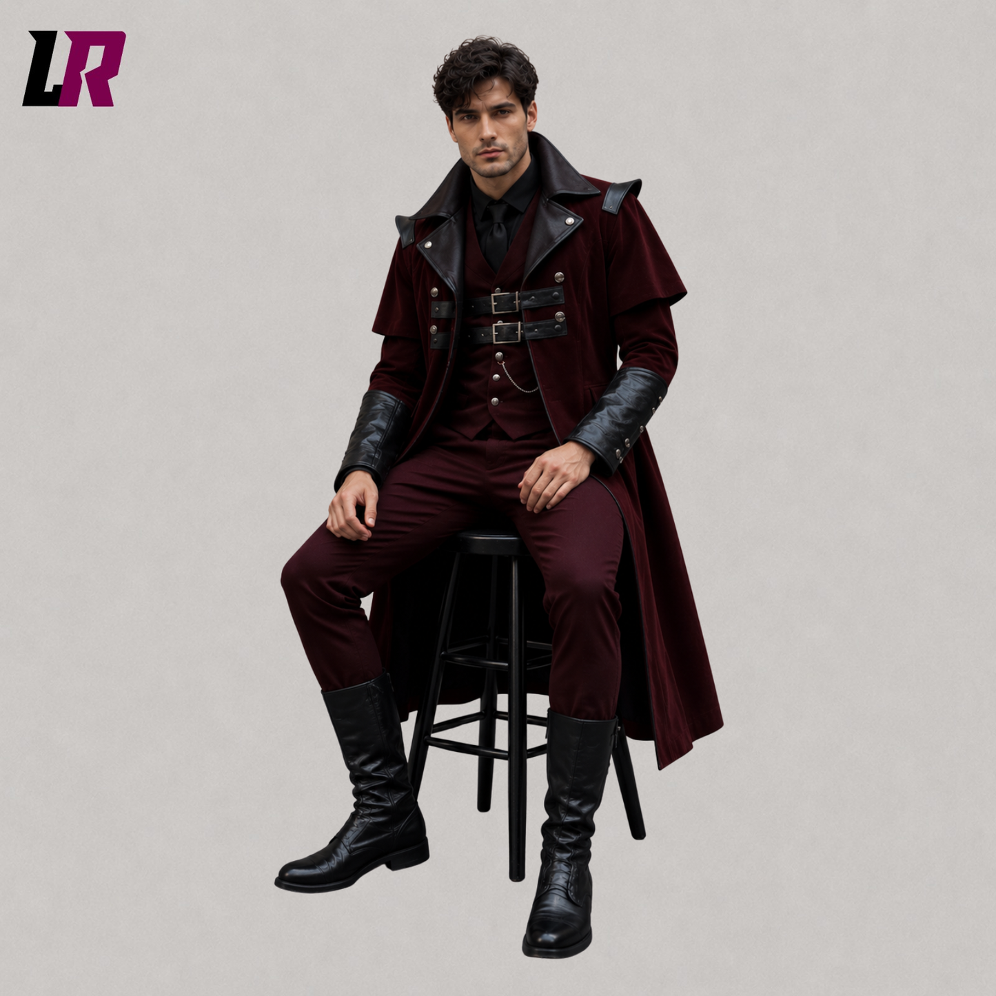 Man sitting on a stool wearing a burgundy velvet Gothic Victorian tailcoat for weddings and formal occasions