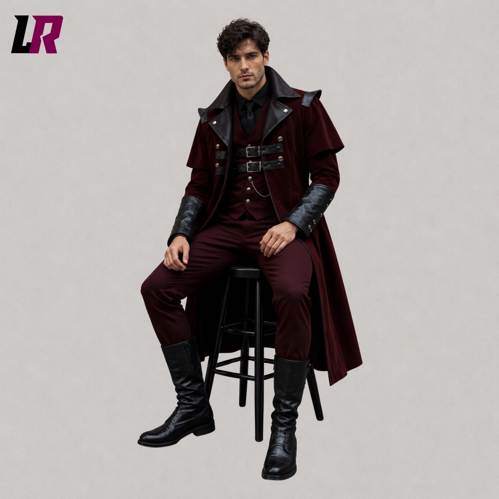 Man sitting on a stool wearing a burgundy velvet Gothic Victorian tailcoat for weddings and formal occasions