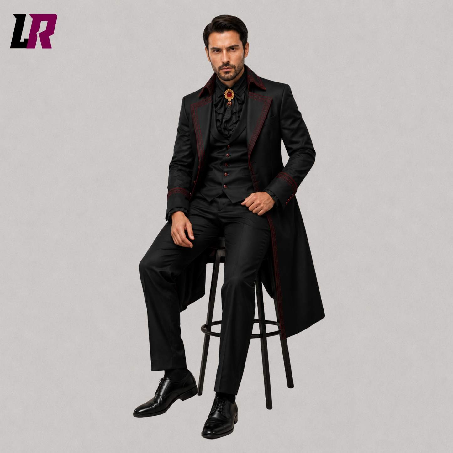Man sitting on a stool wearing a black and burgundy Victorian Gothic tailcoat suit for weddings and formal occasions