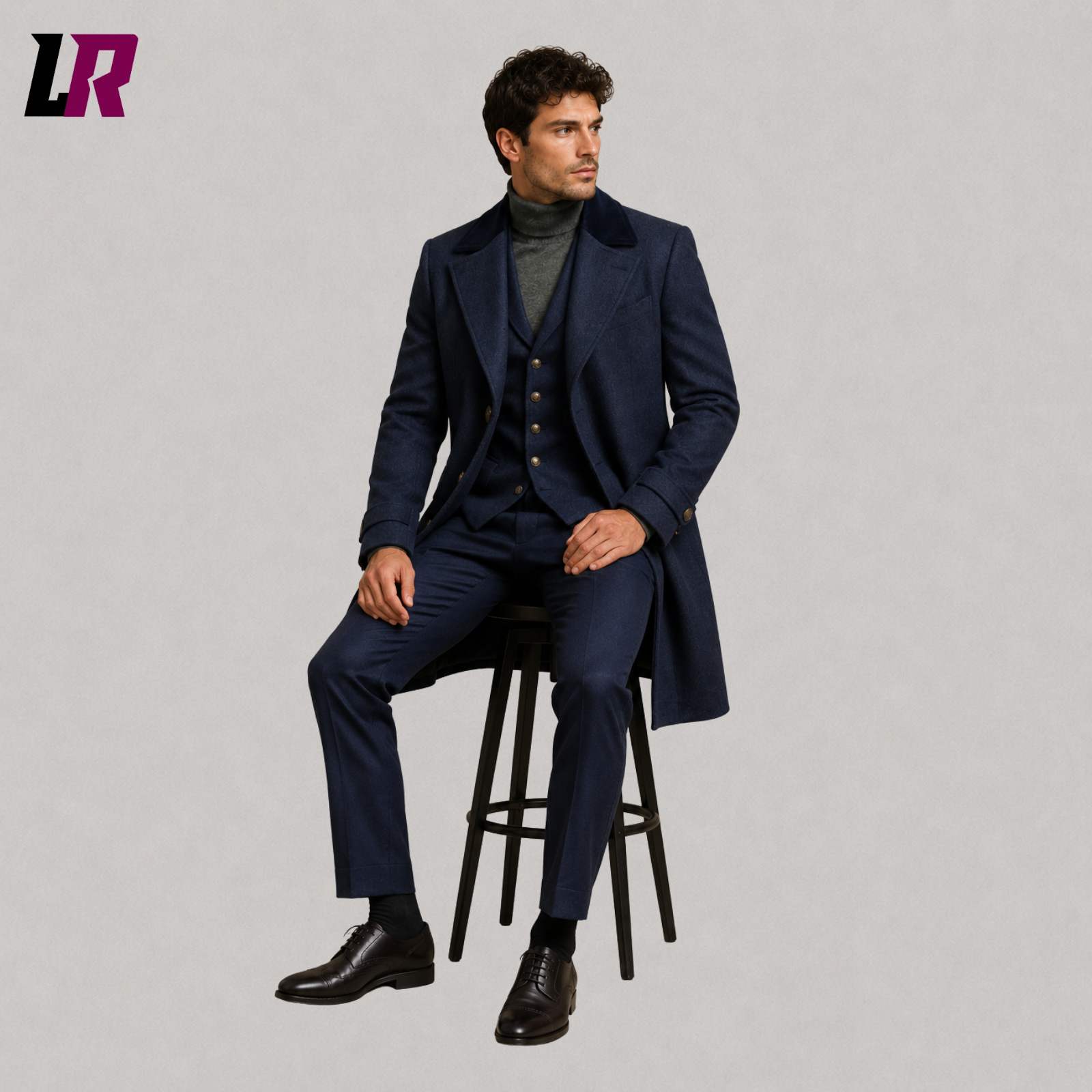 Man sitting on a stool wearing a grey herringbone tweed 3-piece suit with a wool long coat for weddings and winter formal occasions