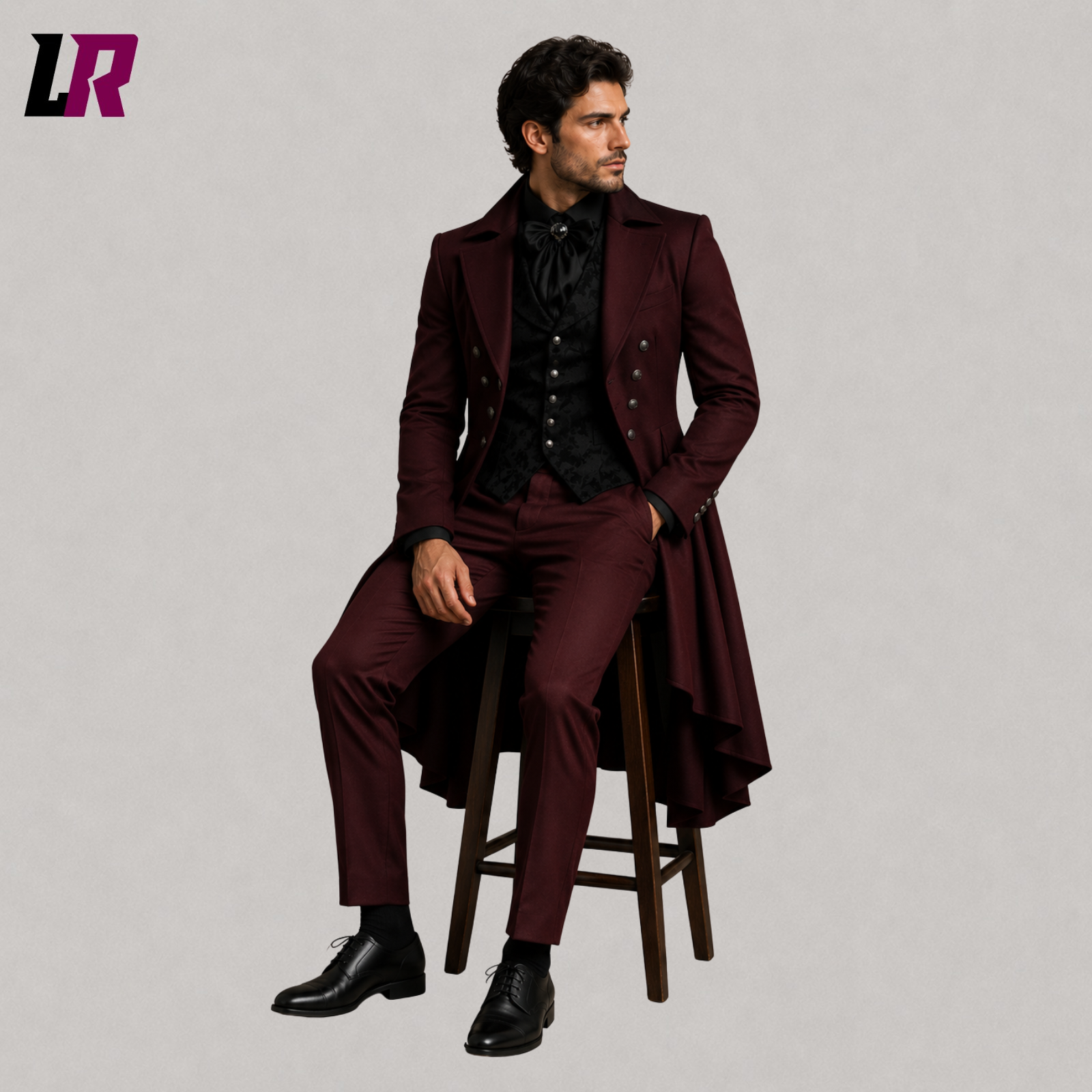 Man sitting on a stool wearing a burgundy Victorian Gothic 3-piece tailcoat suit for weddings and formal occasions