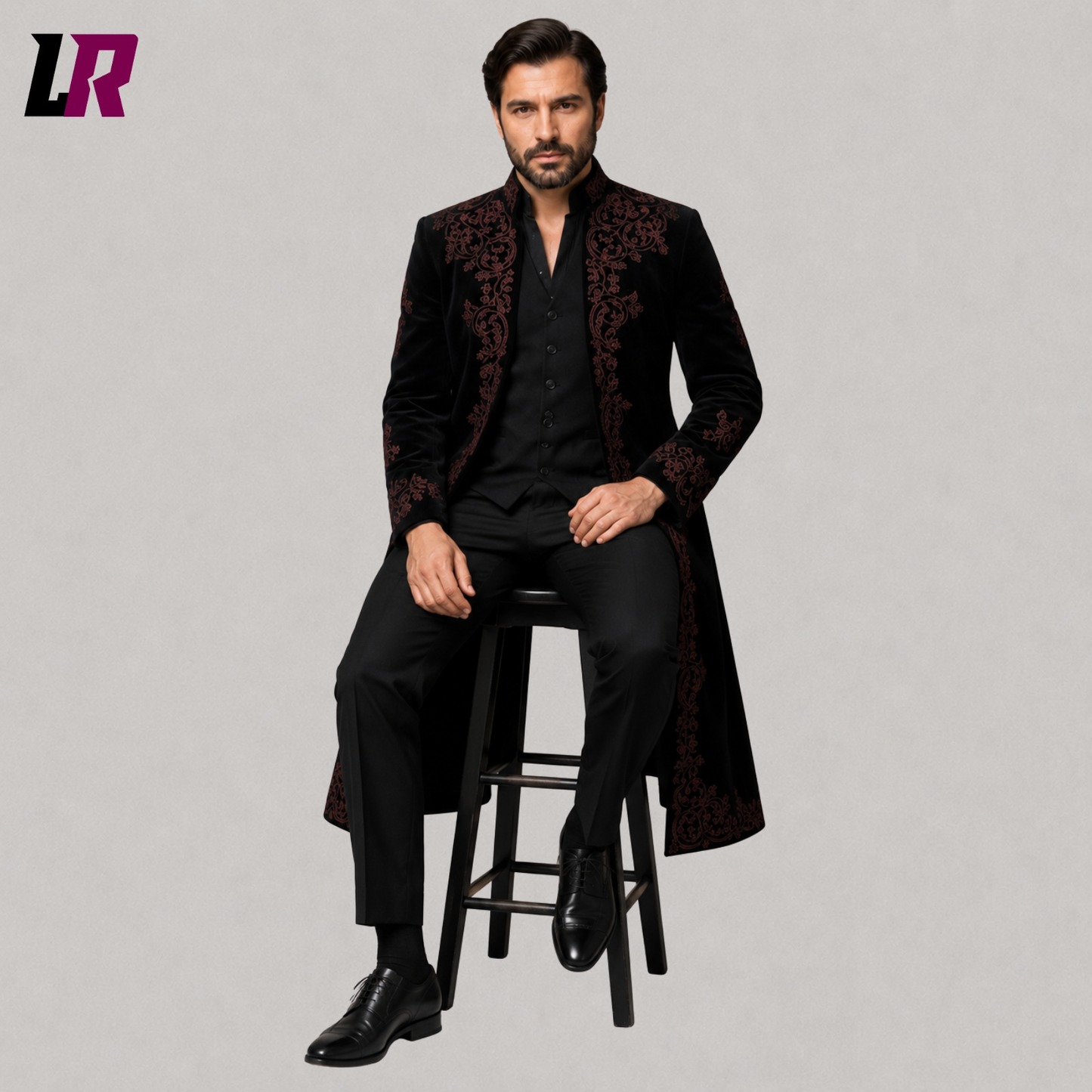 Man sitting on a stool wearing a black velvet Gothic Victorian embroidered 3-piece suit for weddings and formal occasions