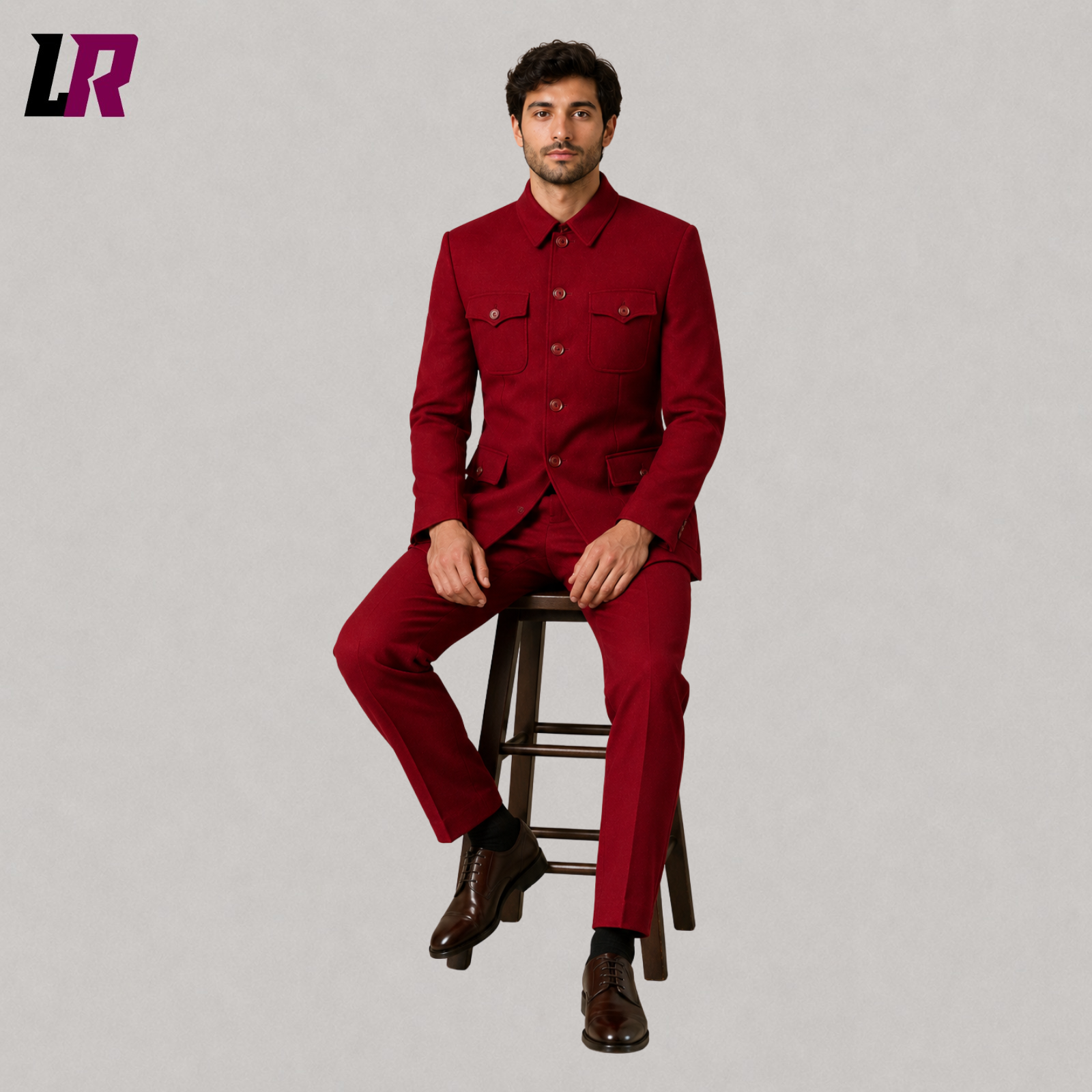 Man sitting on a stool wearing a burgundy Mandarin collar military-style formal suit for weddings and elegant occasions