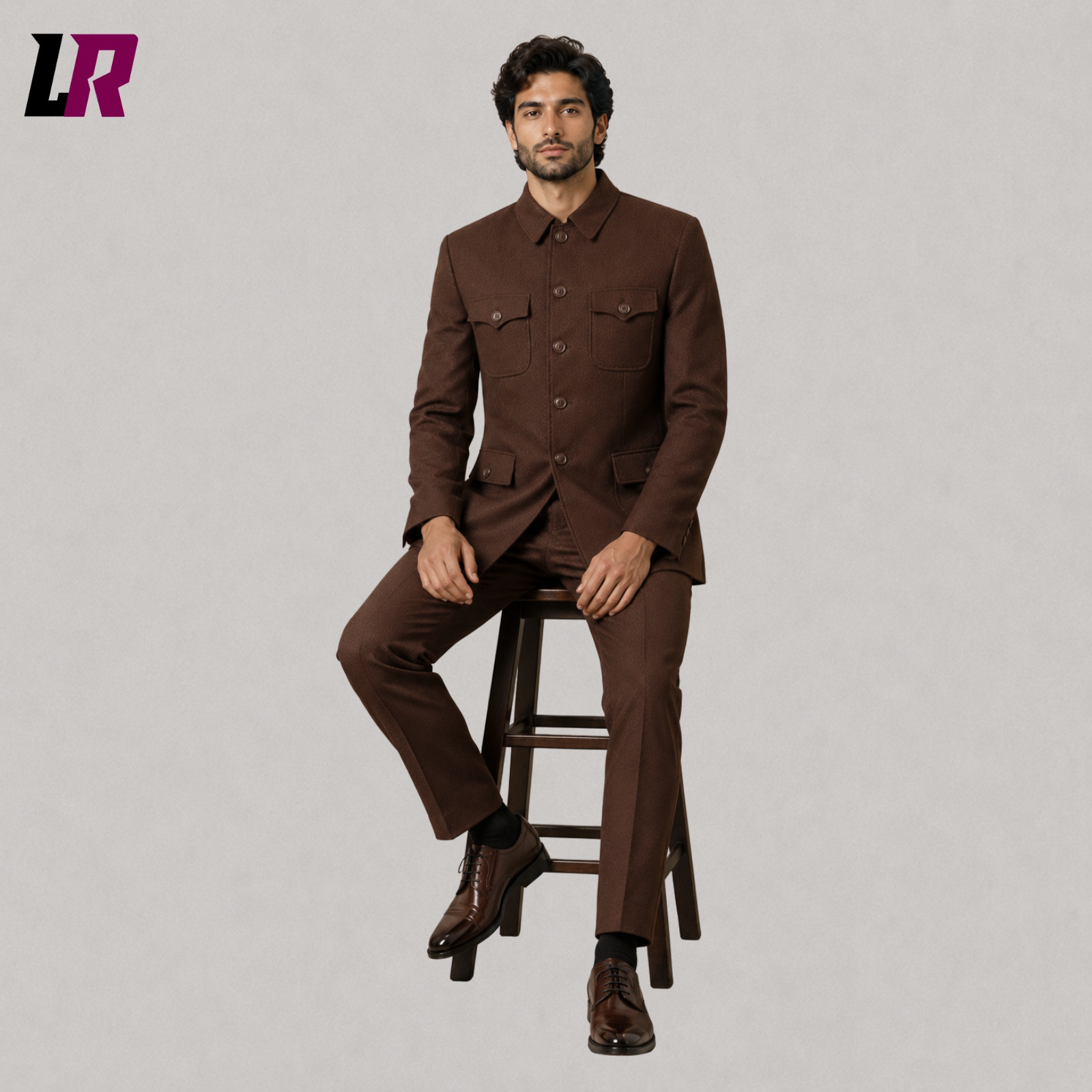 Man sitting on a stool wearing a brown safari military-style formal suit for weddings and luxury occasions