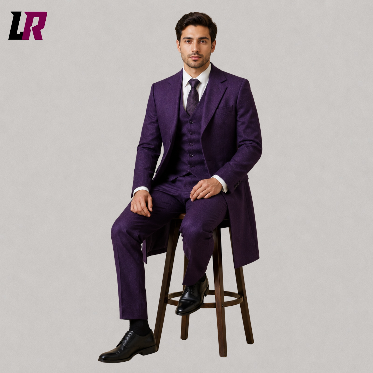 Man sitting on a stool wearing a purple three-piece royal wedding suit with a Victorian-inspired long coat