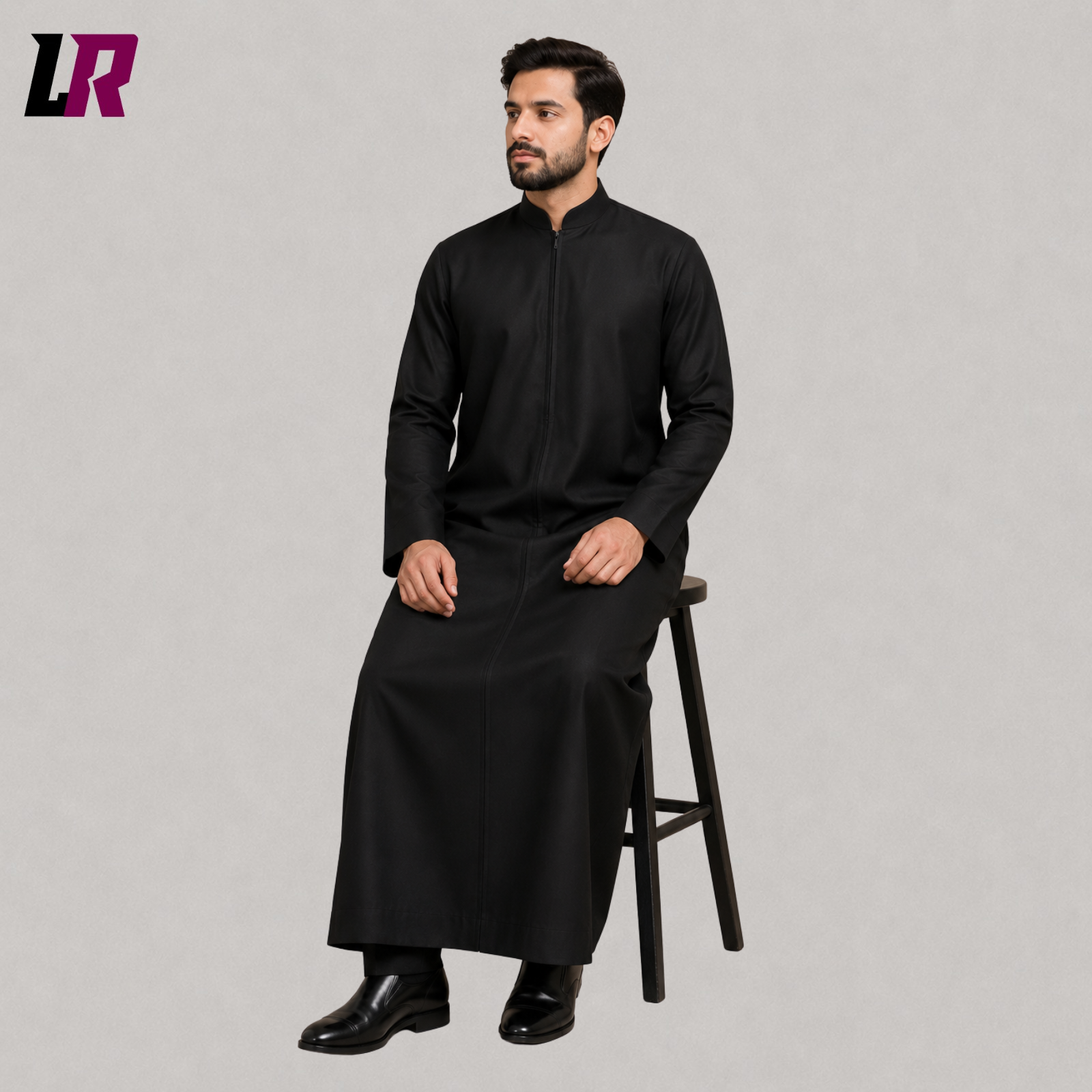 Priest seated on a stool wearing a black custom-tailored clergy cassock with front zipper