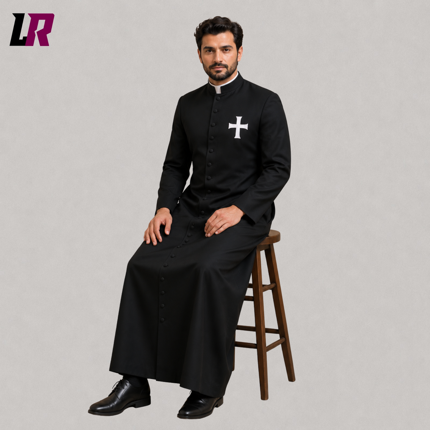 Priest sitting on a stool wearing a custom black cassock with an embroidered cross for Mass and church services