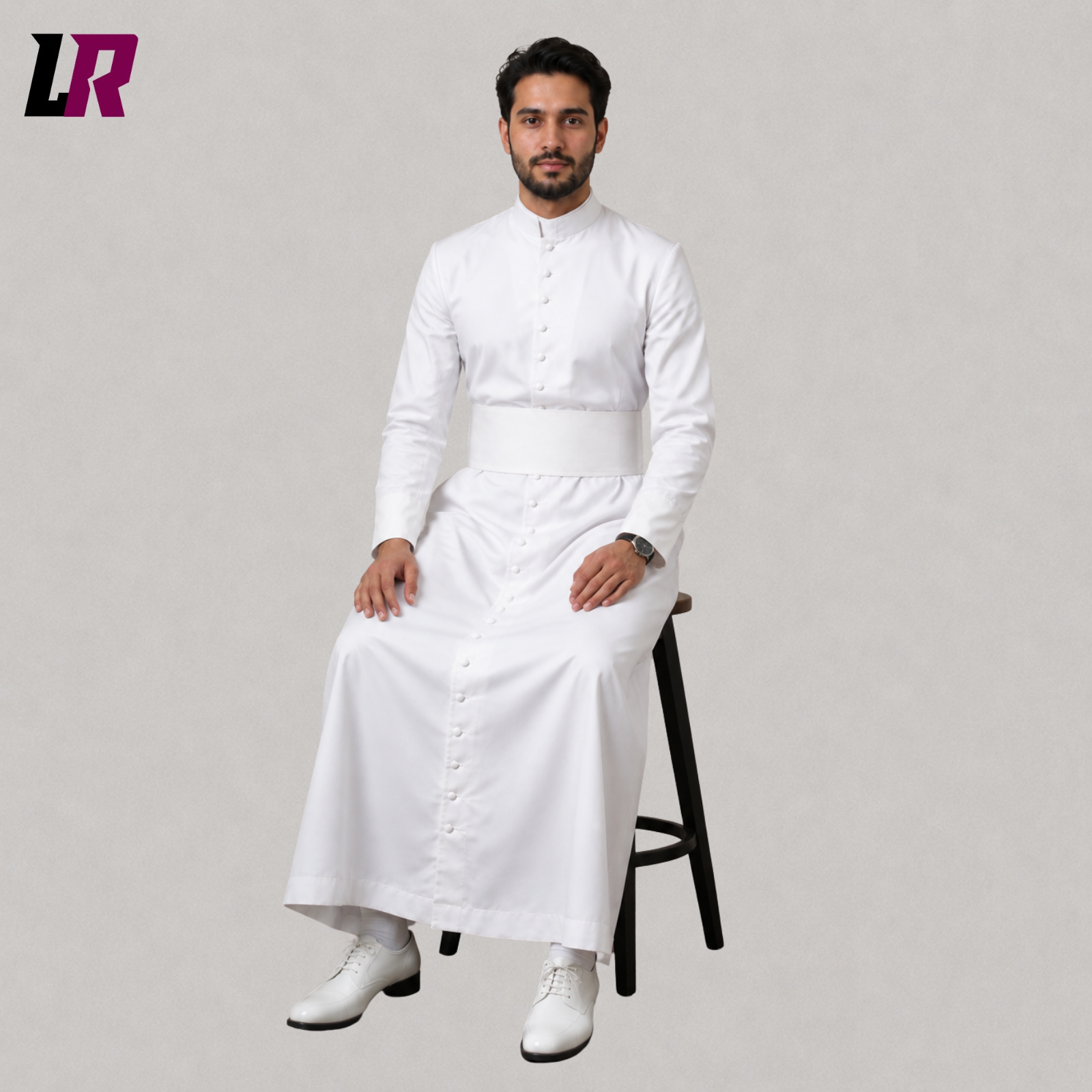 Priest sitting on a stool wearing a custom white Roman cassock for Holy Mass and Catholic church services