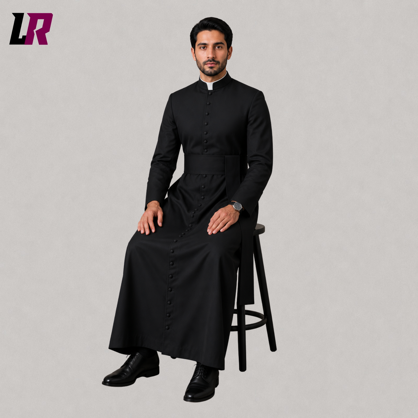Priest sitting on a stool wearing a custom black Catholic cassock for Holy Mass and church services