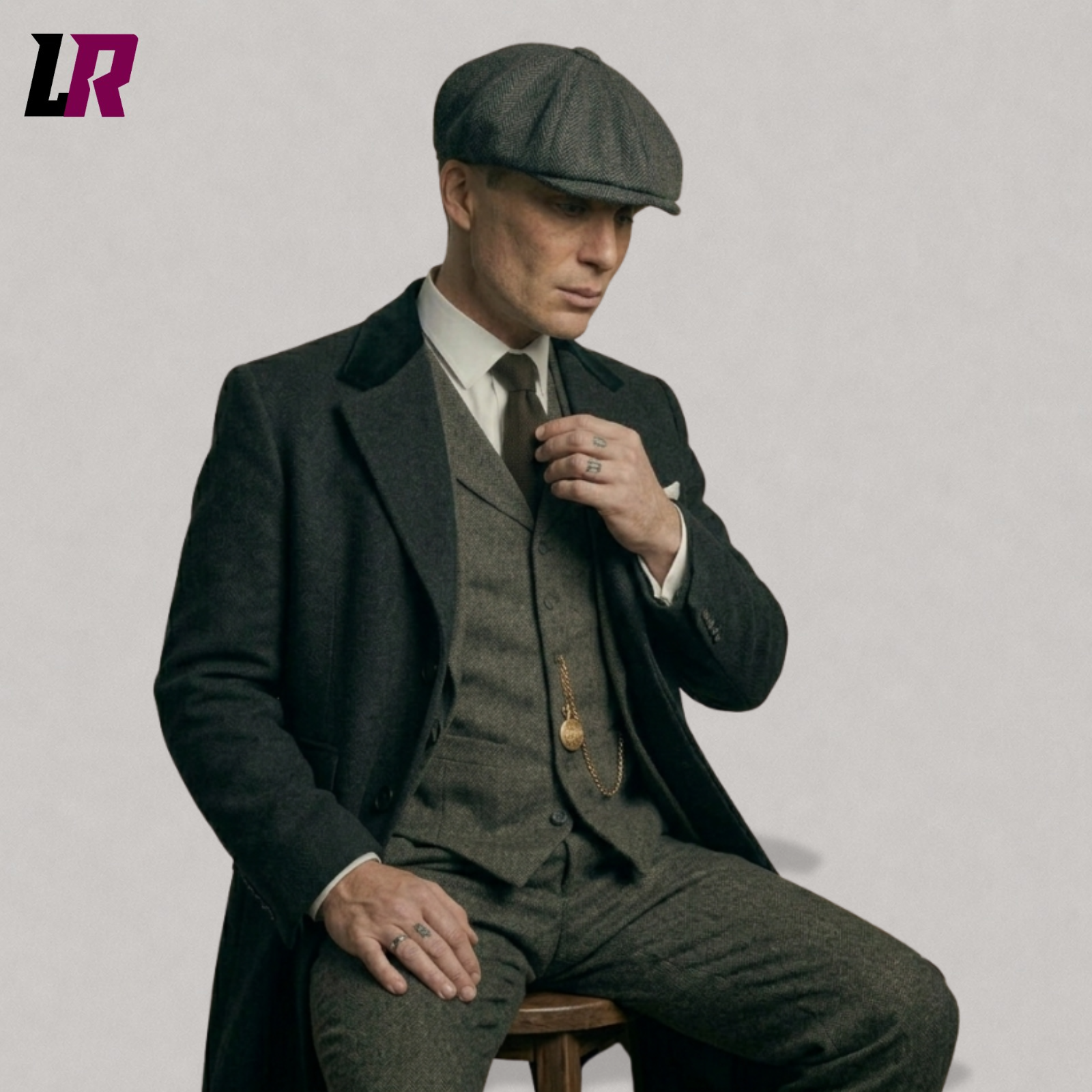 Close-up seated view of men's vintage tweed 3 piece suit with black overcoat and flat cap, 1920s style outfit