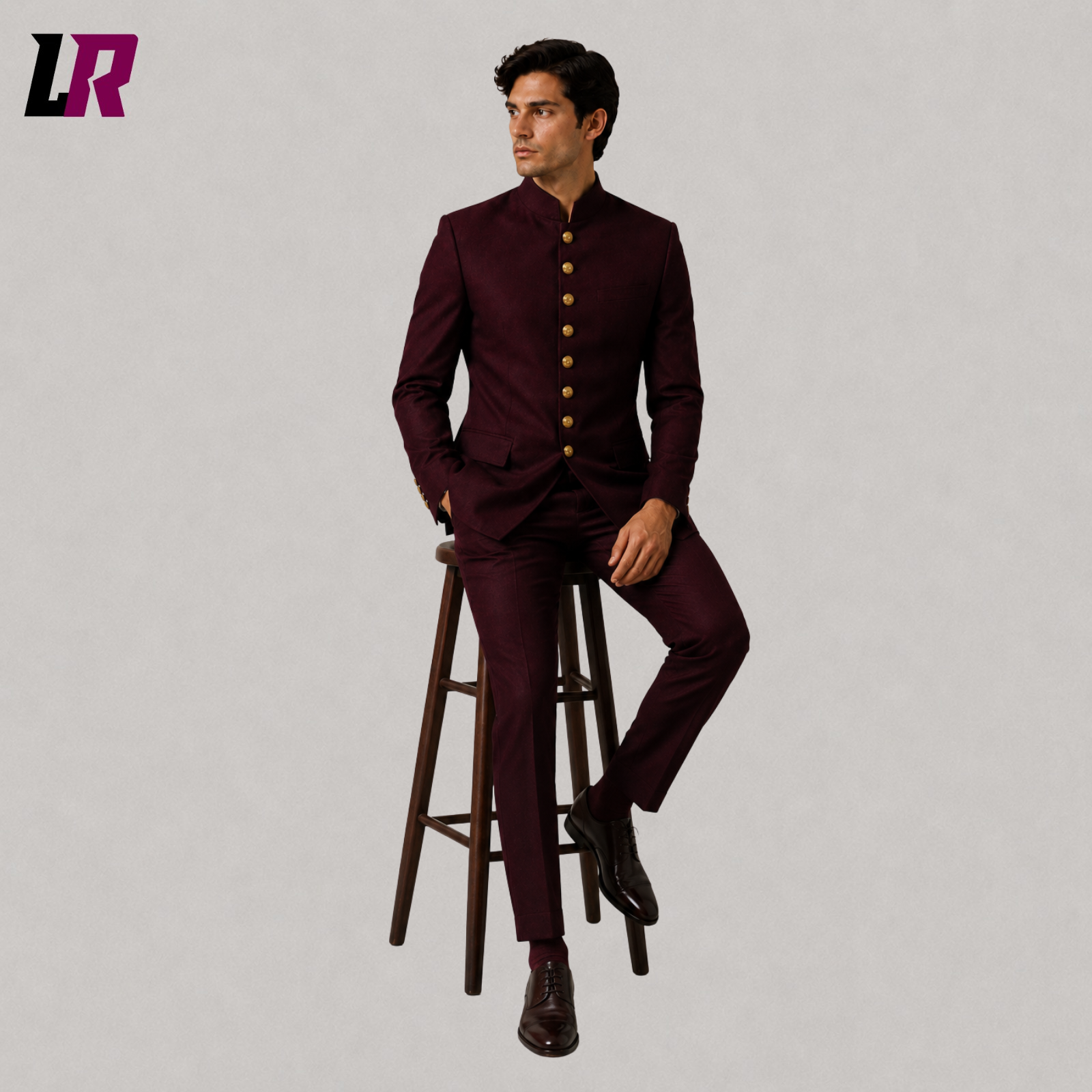 Man wearing a burgundy Chinese tunic Bandhgala suit seated on a stool in a Victorian Gothic Regency jacket