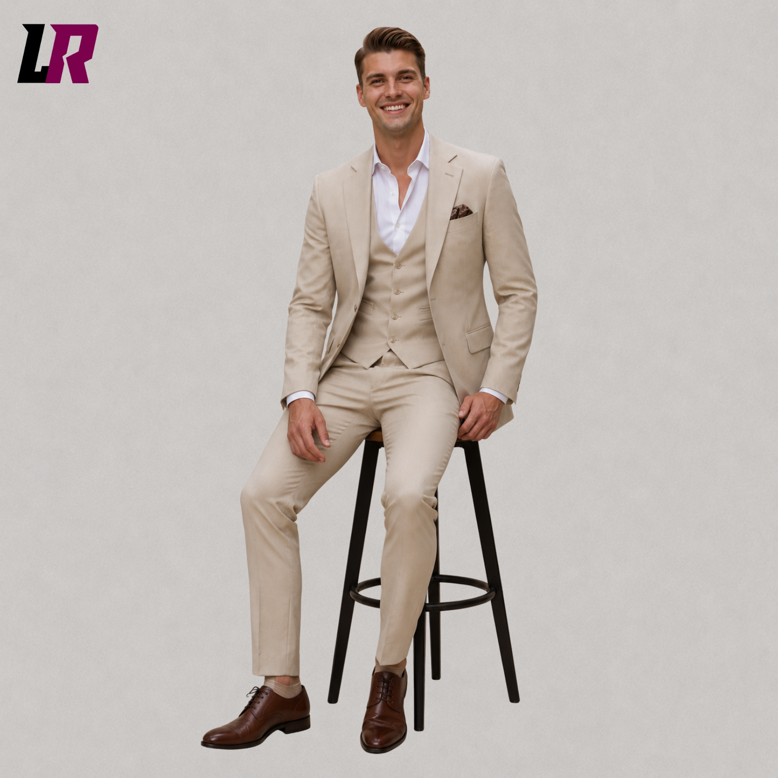 Man wearing a beige 3 piece wedding suit seated on a stool in a formal portrait