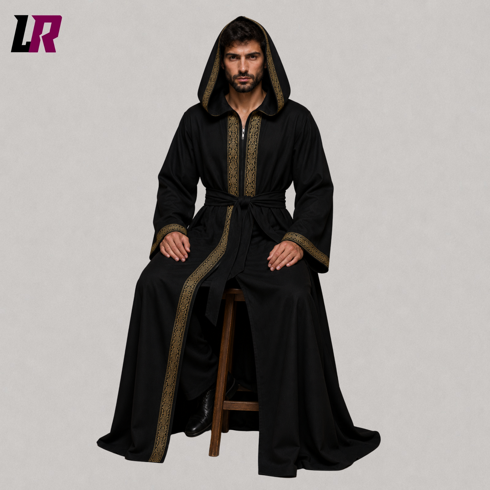 Person wearing a black hooded Gothic cloak seated on a stool in a fantasy medieval costume
