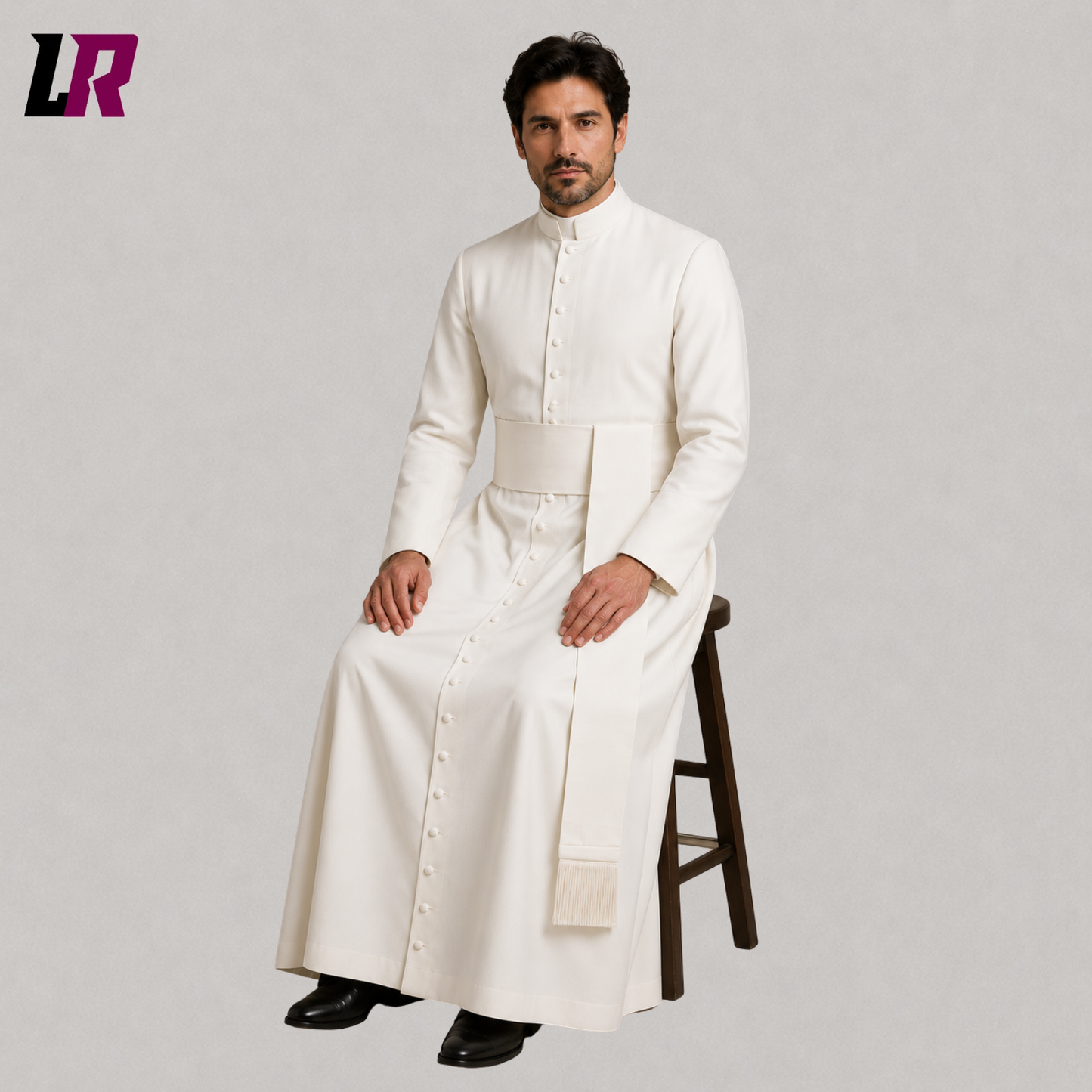 Priest wearing a custom white clergy cassock seated on a stool in a formal portrait