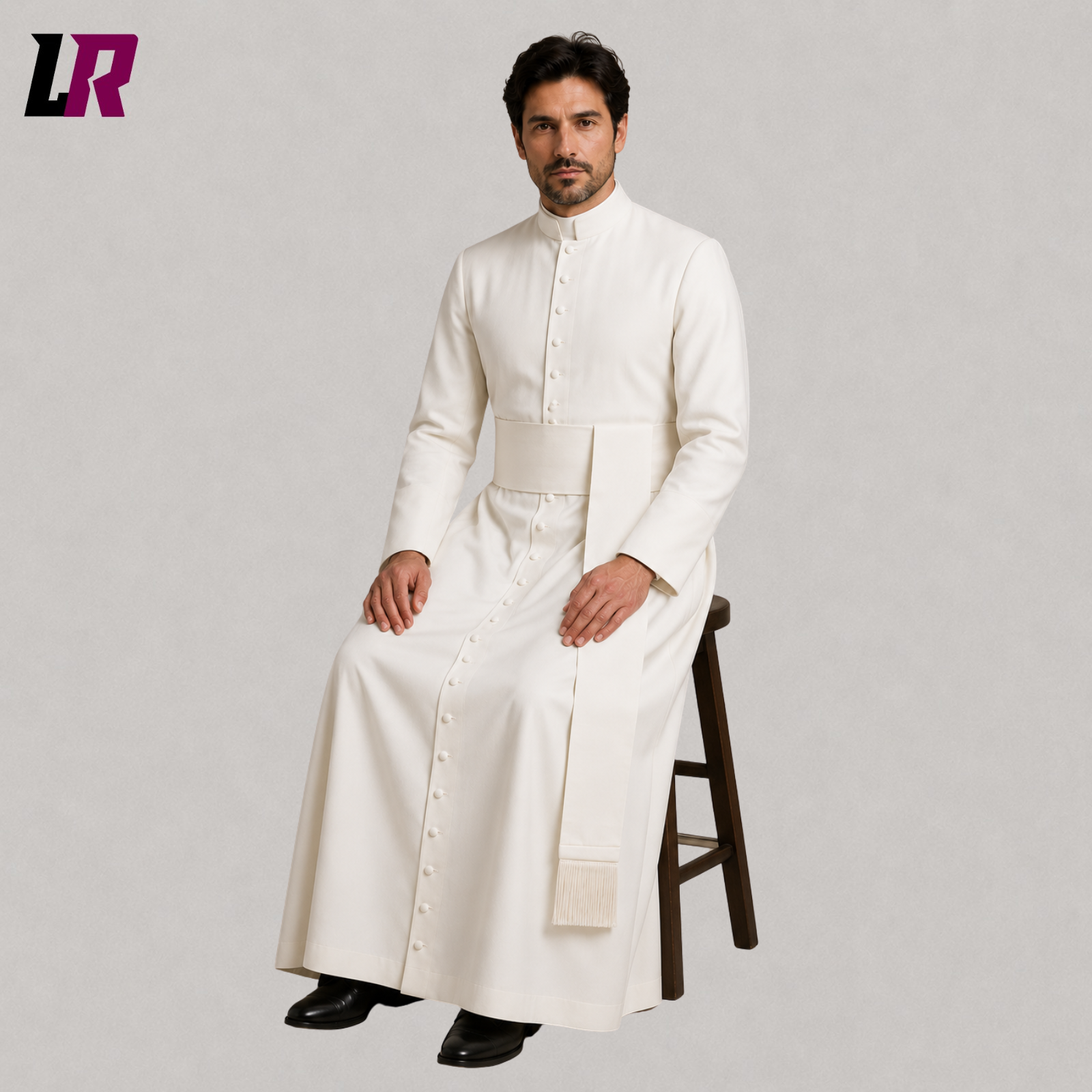 Priest wearing a custom white clergy cassock seated on a stool in a formal portrait