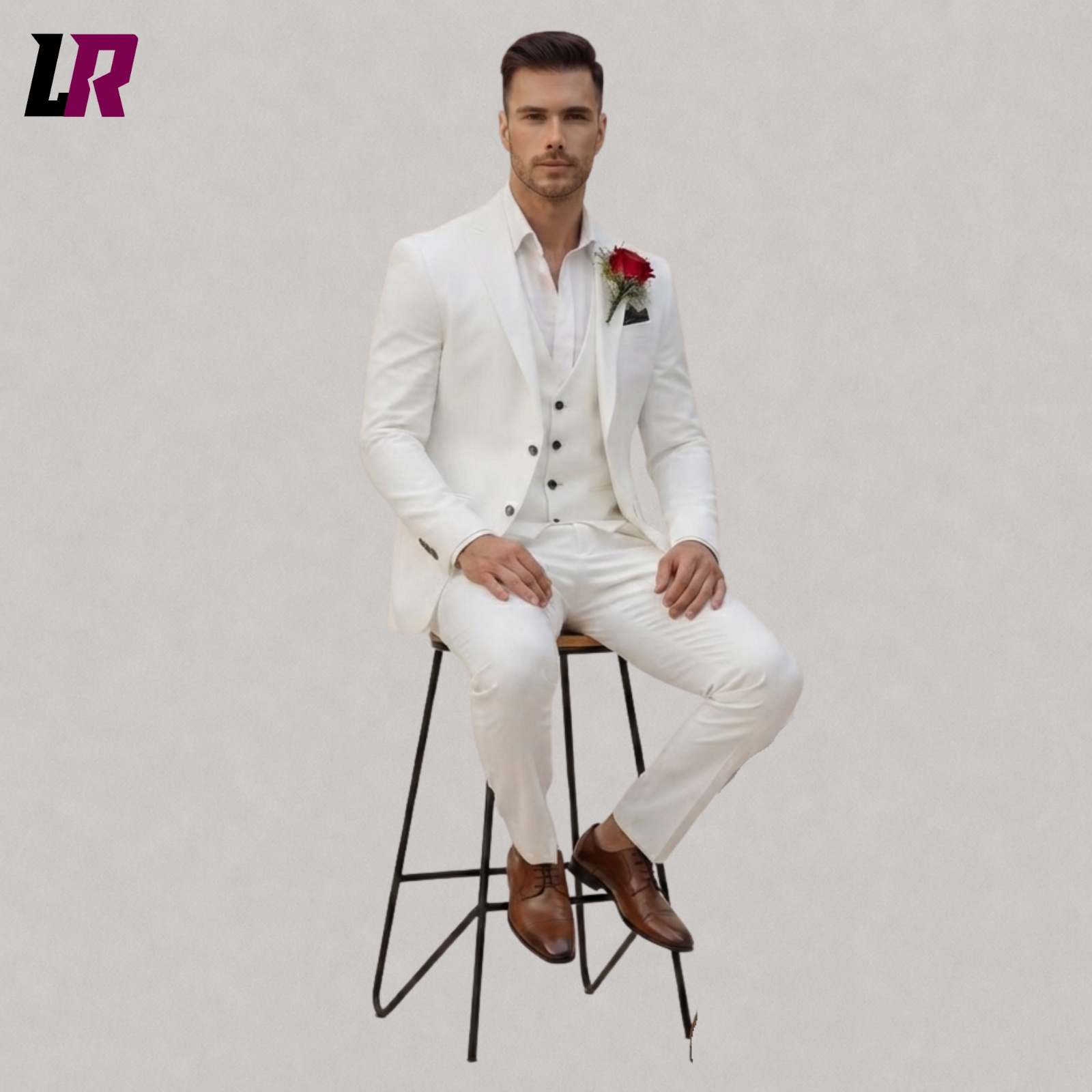 Man wearing white wedding suit seated on stool in elegant groom formal portrait